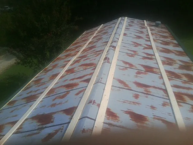 Rusted metal roof panels with new wood purlins before replacement — Storm Damage Roof Repair in New Richmond by Roofing Brothers