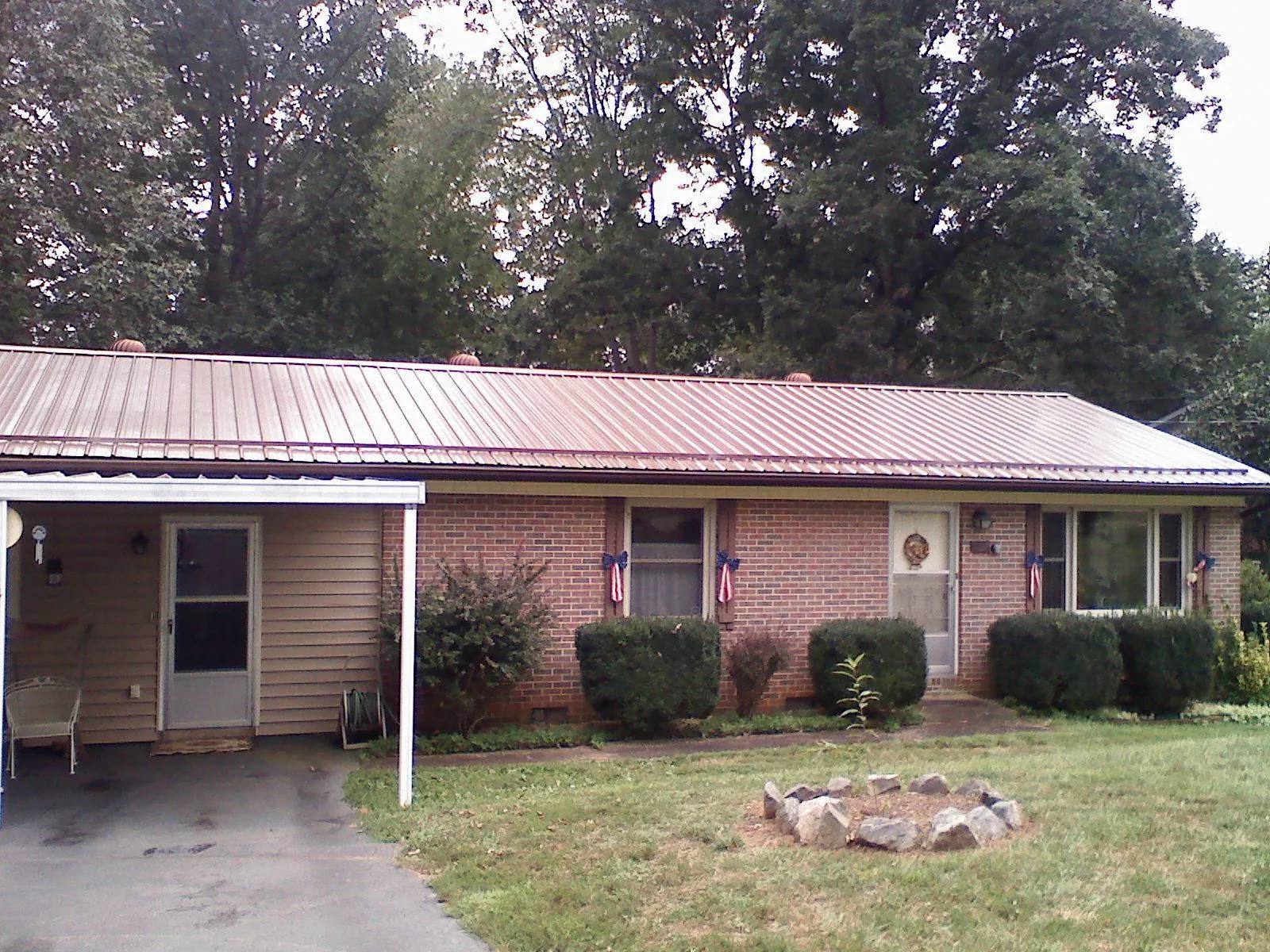 Bronze metal roof and carport on a brick ranch home — Roof Repair work by our crew in New Richmond