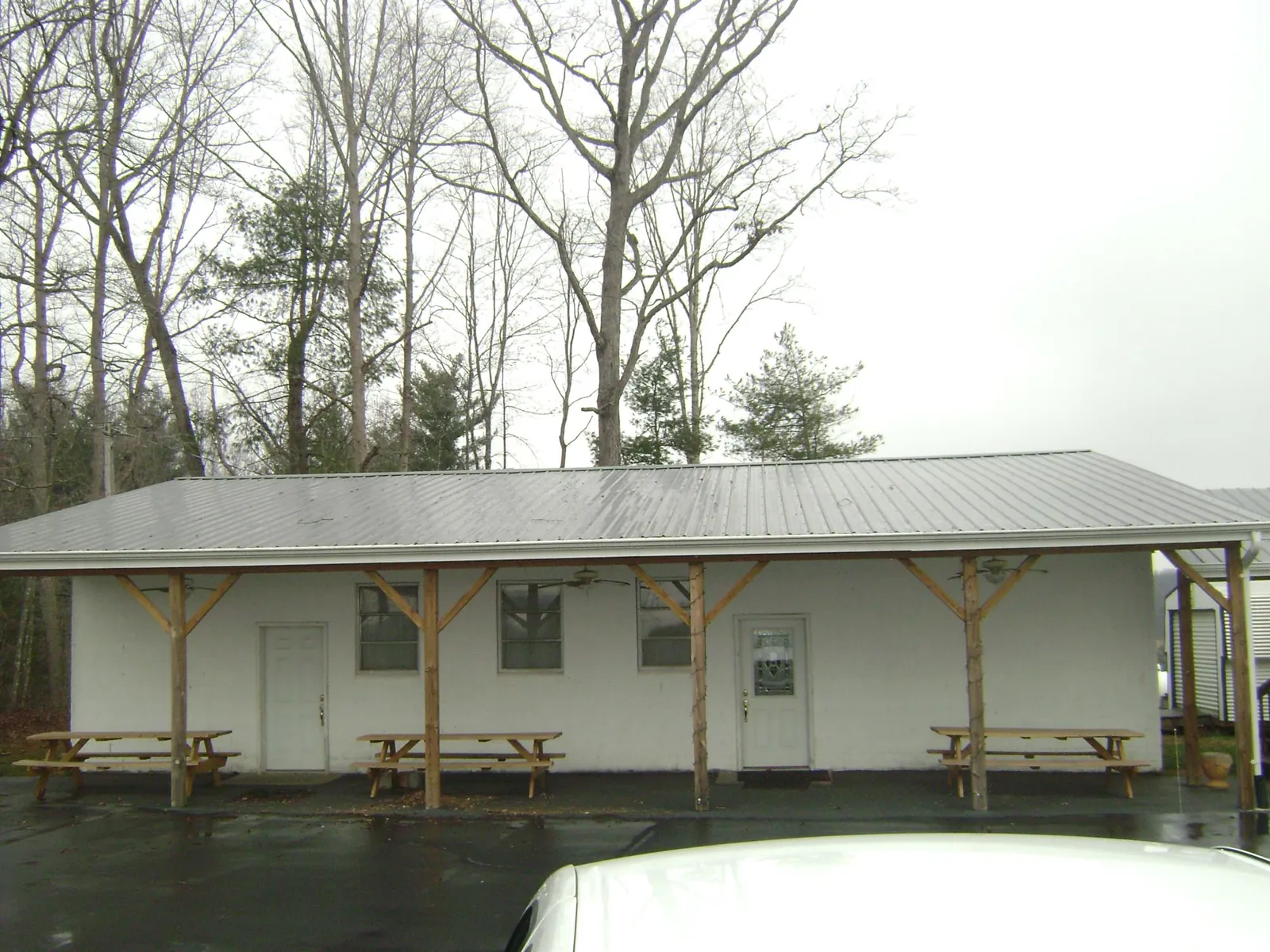 Gray metal roof over a block building with a timber post porch in New Richmond