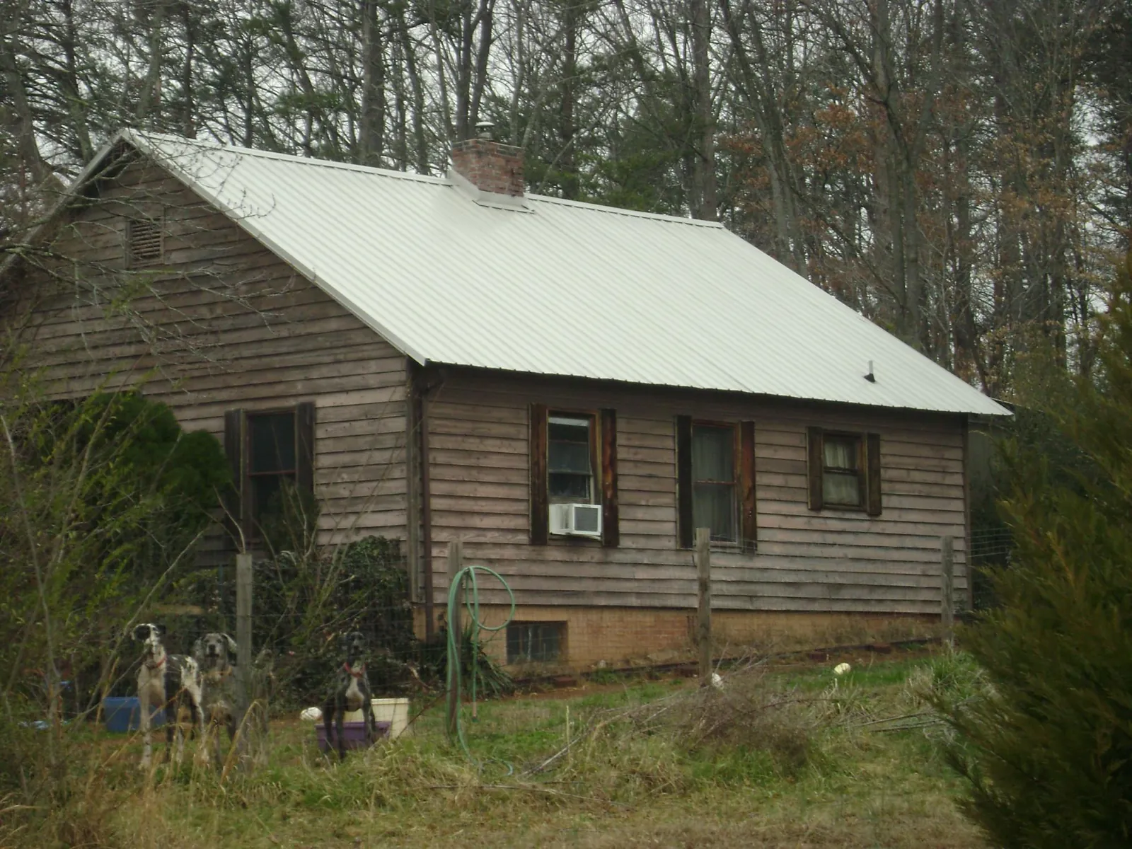 White metal roof on an old wood sided farmhouse, from a Metal Roof Installation job in New Richmond